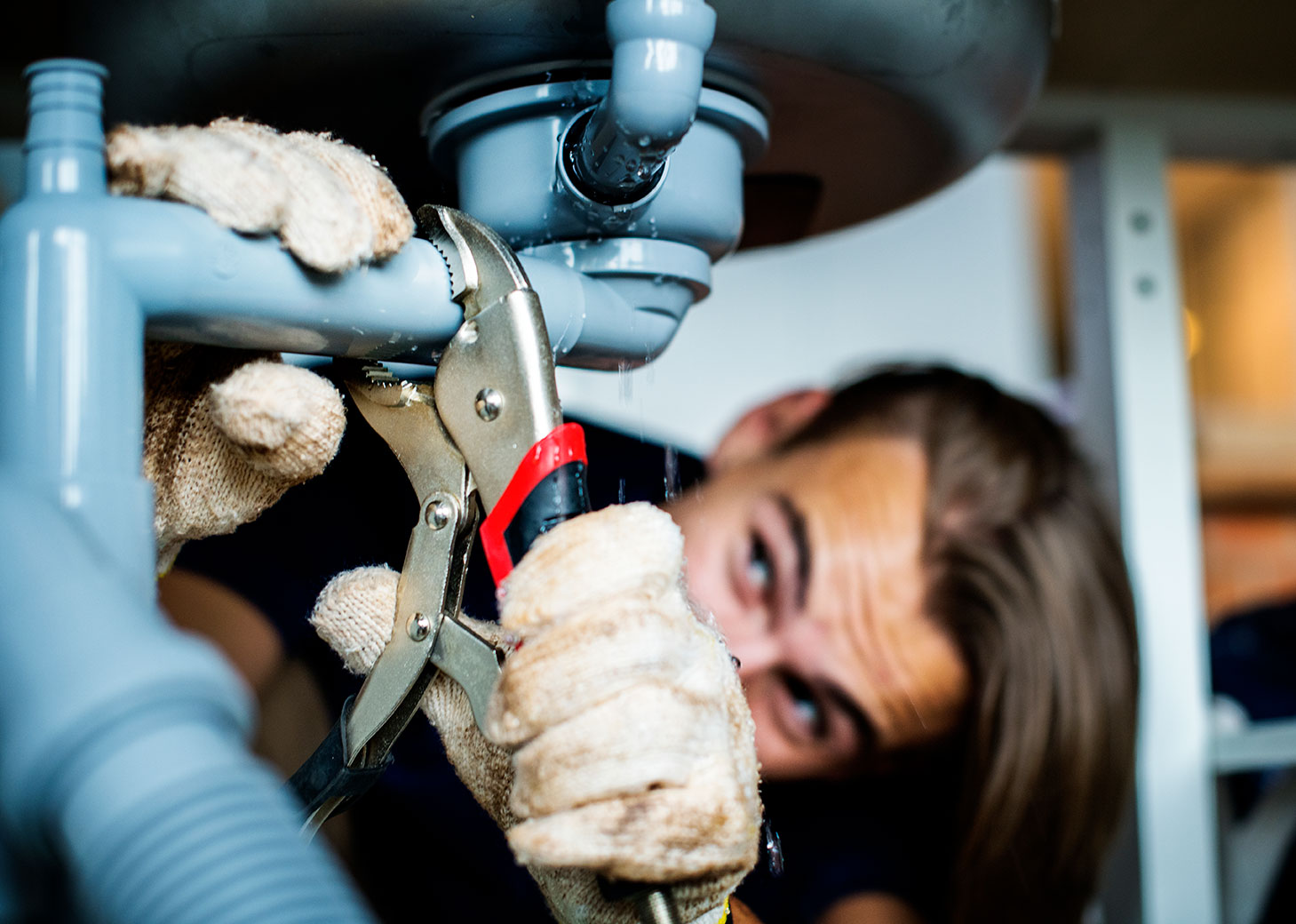 Man fixing kitchen sink leak